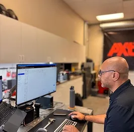 An engineer writing software for the cell at a workstation