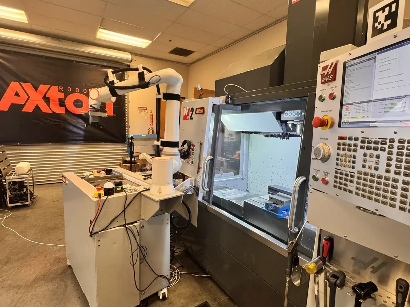 Inside the Axton shop in San Diego: an Axton cobot tending a Haas VF-2