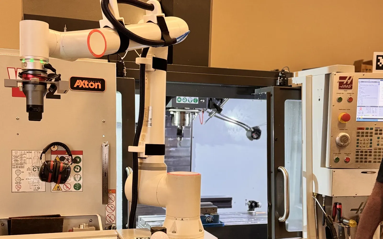 Plug-and-play cobot machine tending station beside a Haas CNC mill in the Axton Robotics shop